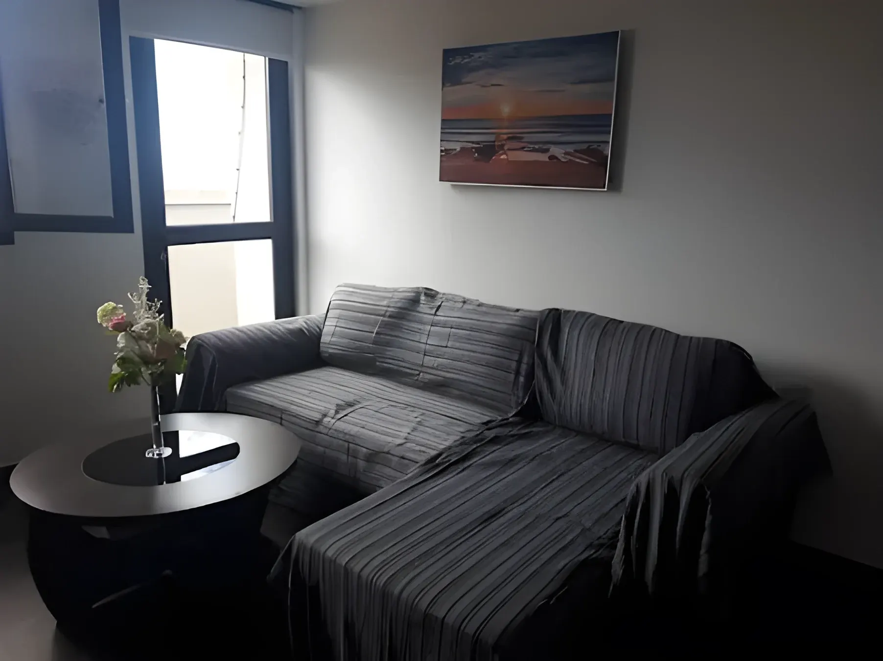 Salón con sofá esquinero y mesa junto a la ventana