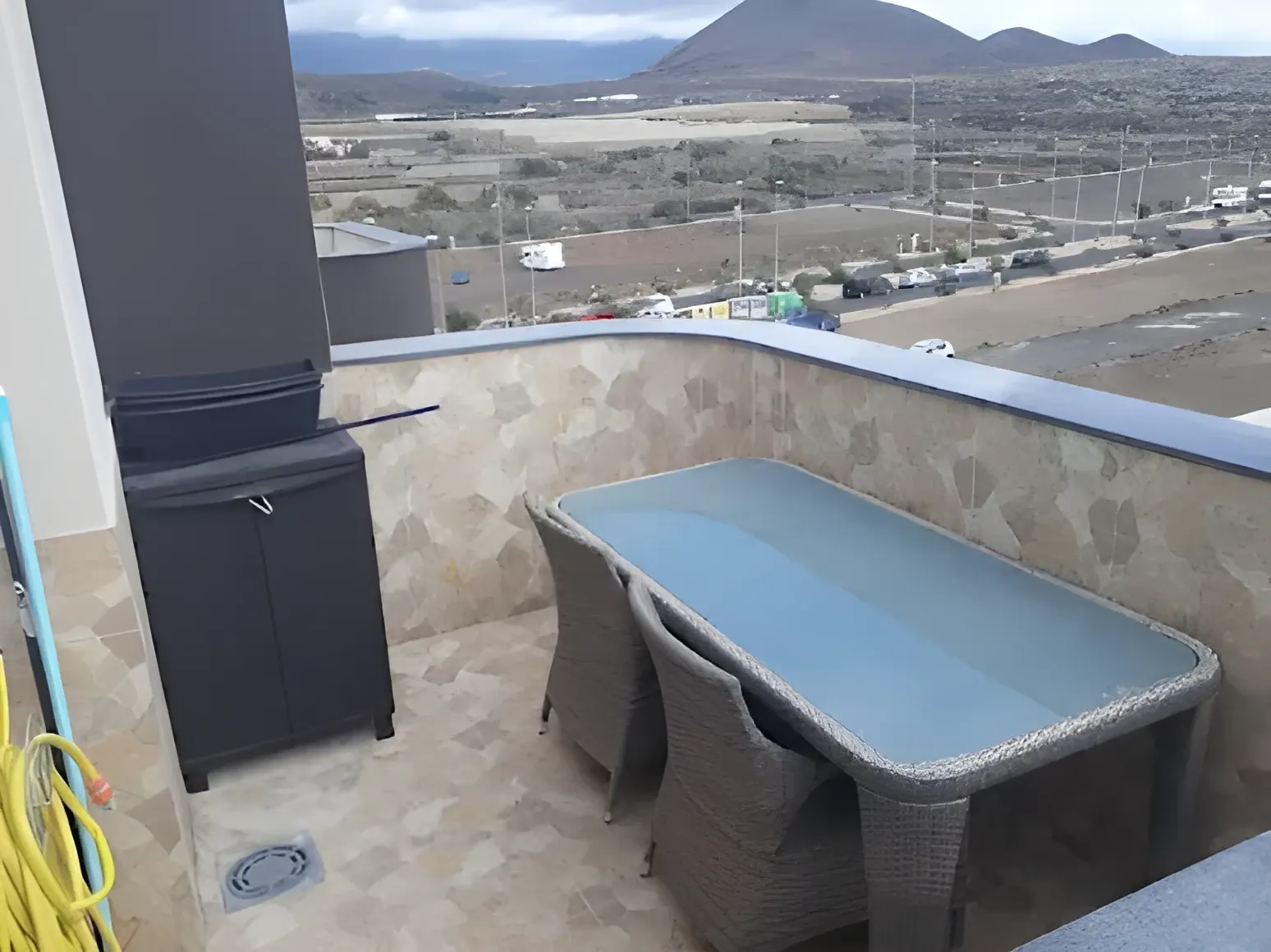 Mesa y sillas en la terraza, con el valle de Güímar al fondo